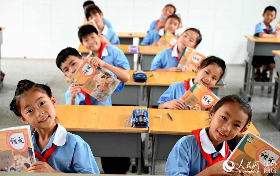 徐州市銅山區的小學生們展示他們剛領到的新書。李曉東攝