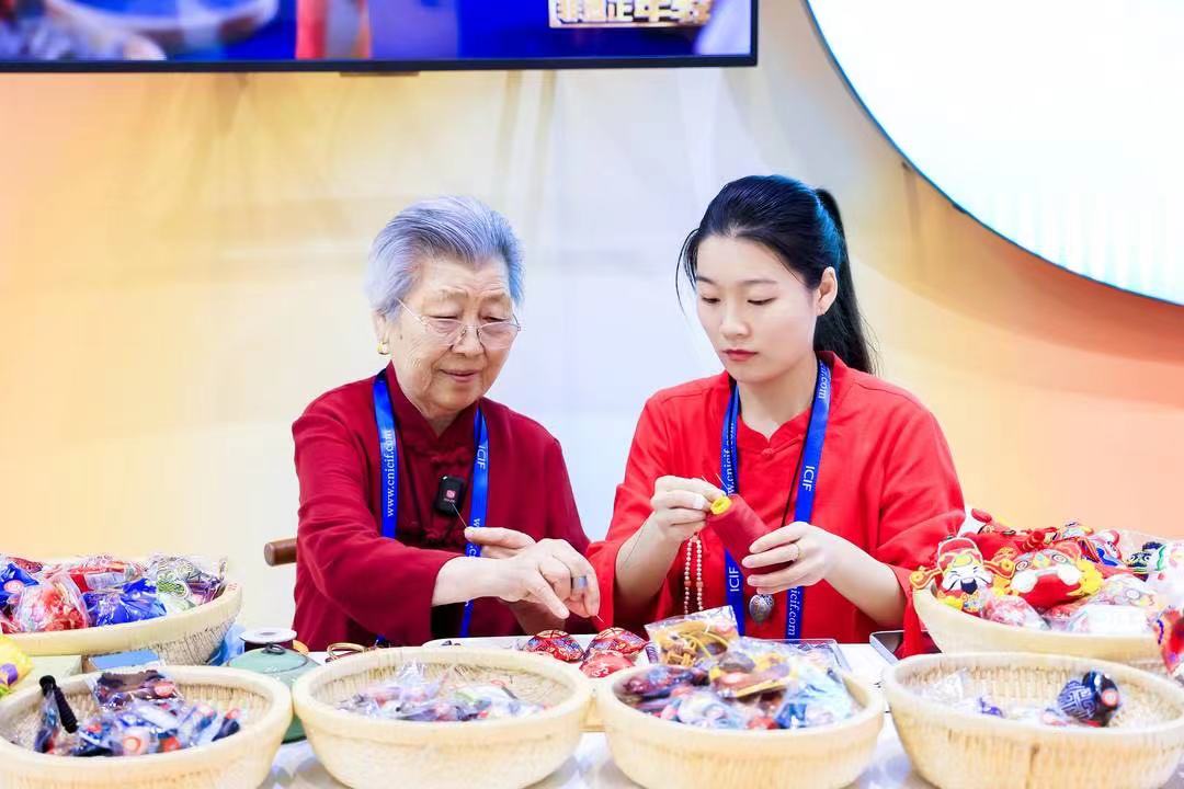 王秀英和孙女在深圳文博会上展示马庄香包。受访者供图